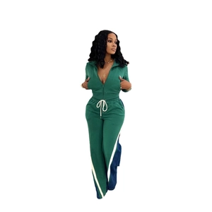 Detail of dark green tracksuit featuring contrast stripes on trousers and drawstring waist