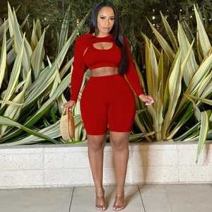 Detail of red athletic crop top with chest cutout and high waist gym shorts