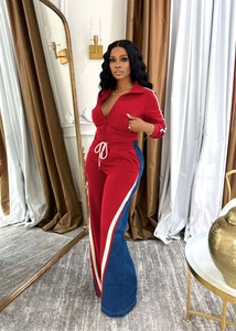 Detail view of red and royal blue patchwork track jacket and pants with white side stripes