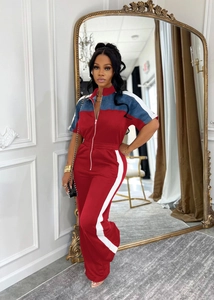 Detail of red and navy color-block jumpsuit with front zipper and side stripes