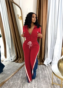 Close-up of stylish color-block tracksuit with red zipper top and blue striped jogger pants