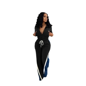Detail of a black sporty set with V-neck zip top and striped wide leg pants for women
