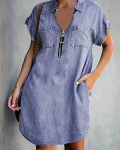 Detail of blue denim shirt dress showing V-neck zip closure and front patch pockets