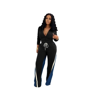 Detail of women's black tracksuit with white drawstrings and denim patchwork stripes