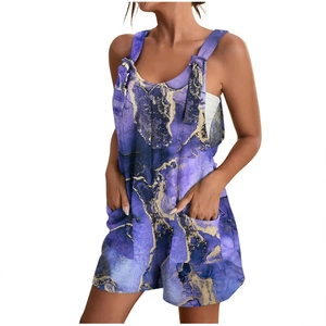 Detail of summer romper featuring purple marble print, wide straps and large front pockets
