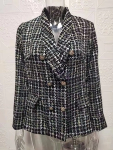 Detail der Tweed-Struktur und der goldgeprägten Knöpfe an der zweireihigen Damenjacke