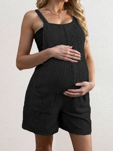 Detailopname van zwarte zwangerschapsjumpsuit met gebreide textuur en zijzakken