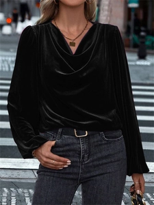 Detail of elegant black velvet long-sleeve top featuring a soft draped cowl neckline style