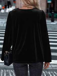 Detail view of black velvet long sleeve top showing draped back fit in outdoor light