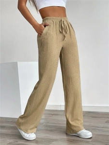 Detailed texture of khaki elastic drawstring waist trousers in breathable crinkle fabric