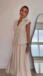Detail of elegant beige two-piece set featuring a tailored vest and pleated chiffon skirt