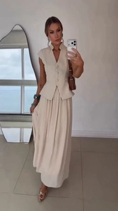 Elegant beige two-piece set featuring a buttoned vest and flowy maxi skirt detail