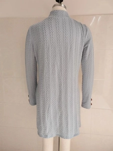 Macro shot of vertical textured knit fabric and button detail on light blue sleeve
