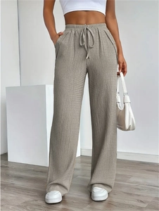Detail of taupe wide-leg casual pants with textured fabric and drawstring elastic waist