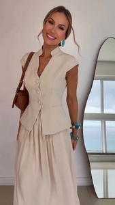 Detail of elegant beige two-piece set featuring slim-fit vest and flowing chiffon maxi skirt