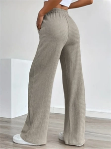 Detail view of khaki waffle knit fabric texture and elastic high waist on wide leg trousers