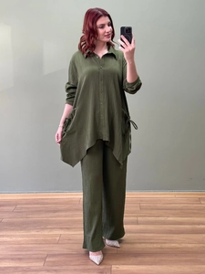 Detail view of the irregular hemline and drawstring texture on dark green shirt set