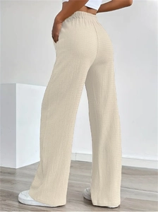 Close-up of beige textured fabric high-waisted wide-leg pants with elastic drawstring waist