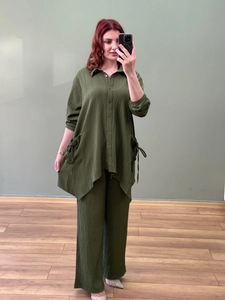 Detailed view of dark green pleated fabric texture on irregular long-sleeve shirt and pants