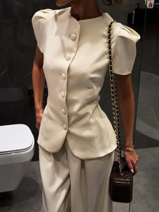 Detail of elegant cream jacket with large buttons and matching wide-leg trousers