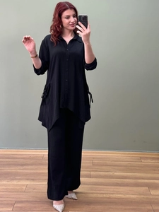 Detail of black two-piece set featuring pleated texture fabric and irregular hem shirt