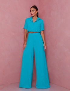 Detailed view of bright blue short sleeve shirt and high waist wide leg pants set