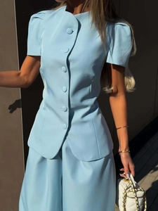 Detailed view of light blue fashion set featuring puff sleeves and elegant fabric texture