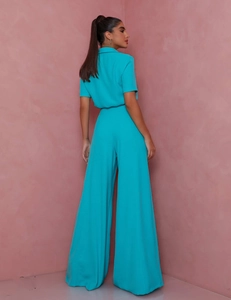 Side view of turquoise two-piece set featuring short sleeve shirt and wide leg trousers