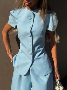 Detail of baby blue two-piece set featuring puffed sleeves and large fabric-covered buttons