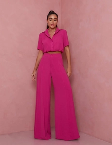 Detailed view of women's short sleeve crop shirt and high-waist wide-leg pants in magenta