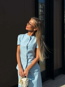 Close-up of light blue short-sleeved jacket with matching buttons and elegant slim fit