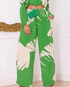 Detail of high-waist wide-leg pants featuring elastic waist and vibrant green print pattern