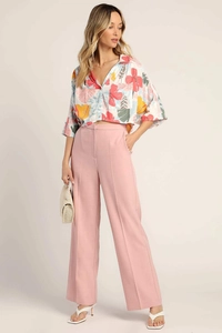 Detail view of floral print shirt paired with pink high waist wide leg trousers