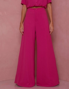 Detail of rose red high-waisted wide-leg trousers with front seam and matching buttons