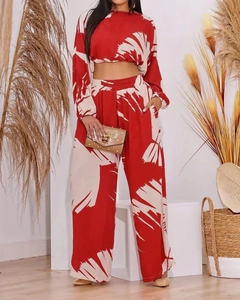 Detailed pattern of red and beige printed crop top and high-waisted wide leg trousers