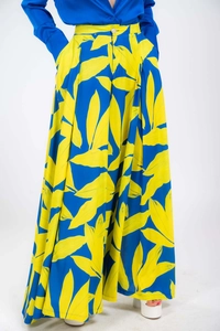 Detail of high-waisted royal blue wide-leg trousers with yellow leaf print and white button