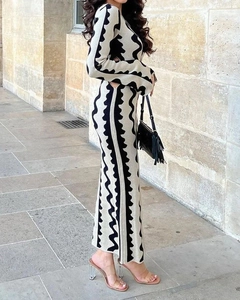 Detail of long sleeve knit dress featuring black and white wave pattern and side waist cutout
