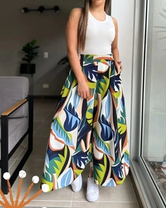 Detail of high waisted wide leg trousers with vibrant tropical leaf print and flowy drape