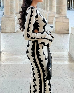 Detailed view of women's long sleeve knit dress with waist cut-out and wavy pattern