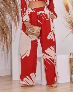 Detail of high waist wide leg pants with abstract red and cream leaf print pattern