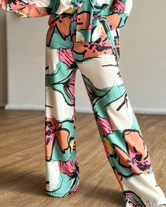 Detail of high-waisted wide-leg trousers with abstract floral print in vibrant colors
