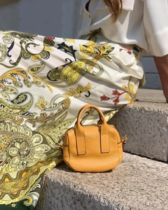 Gros plan du mini sac à main en cuir grainé jaune vif avec poignées et fermeture éclair