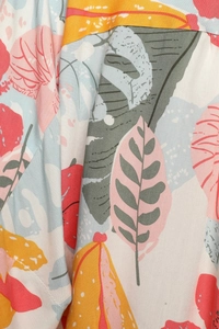 Detail shot of tropical leaf print fabric showing fine stitching and colorful floral pattern