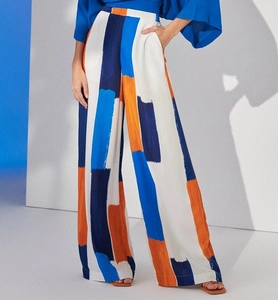 Detail of high-waisted wide-leg trousers featuring artistic blue and orange geometric prints