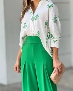 Detail von weißem Hemd mit grünem Blattmuster und Hose mit weitem Bein für Damen