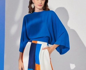 Detail of elegant royal blue satin top with wide sleeves and geometric print wide-leg pants