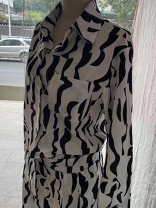 Detail eines Langarm-Shirts mit Zebra-Print, Brusttasche und weißen Knöpfen