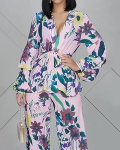 Detail of floral V-neck top with waist tie and matching trousers in light pink