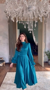 Détail de la robe en satin bleu paon avec manches lanternes plissées et col montant chic