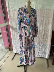 Detail of tropical floral print on women's V-neck tie-waist shirt and wide-leg trousers set